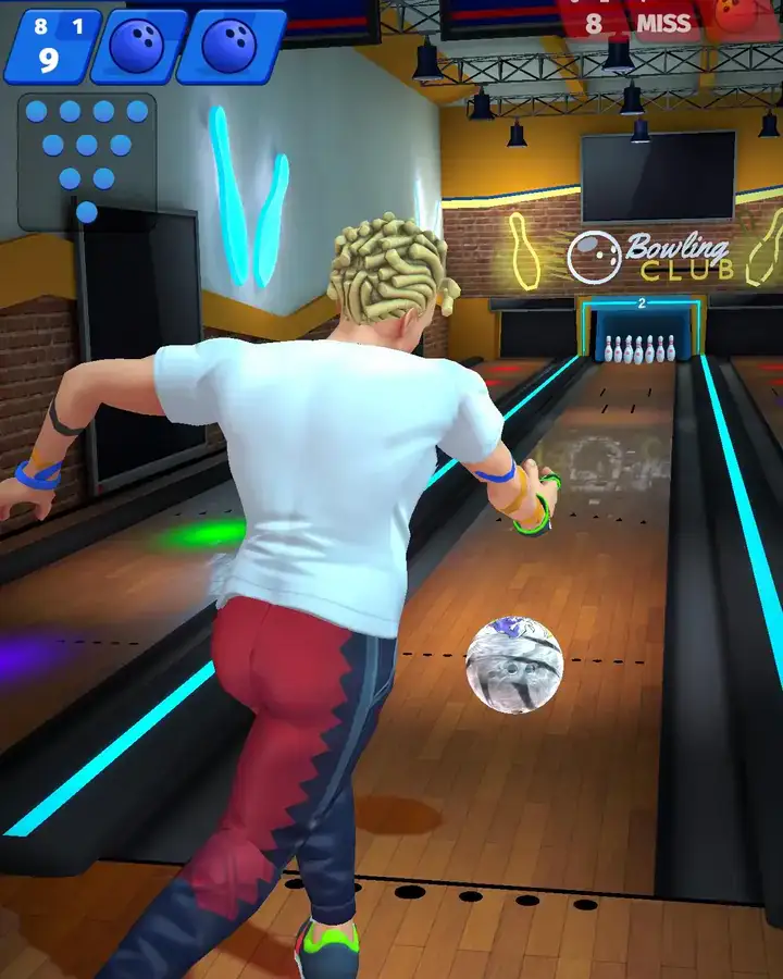 Jogador a lançar a bola numa pista de bowling iluminada, no Bowling Club